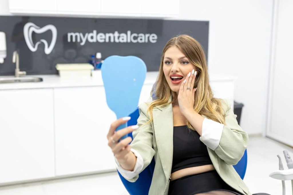Pacientă admirându-și zâmbetul la clinica MyDentalCare Huedin