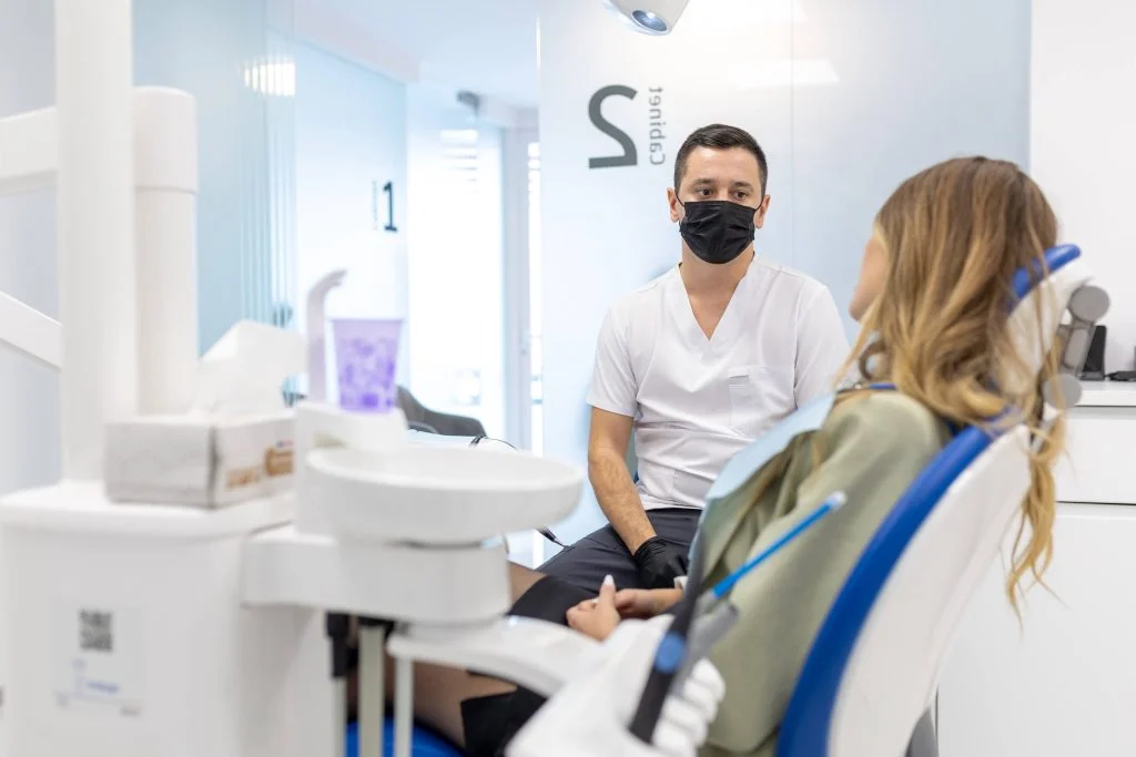 Medicul stomatolog discută calm cu un pacient în timpul unei consultații la MyDentalCare Huedin